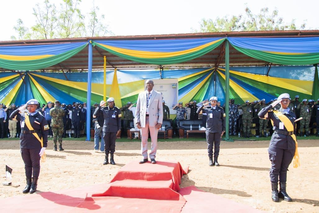 Dr. Gassama standing on the red carpet during the Rwanda FPU medal ceremony as officers salute